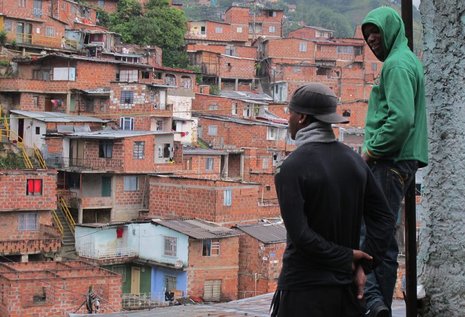 Zwei Jugendliche, die regelmäßig zu dem Kulturverein kommen, blicken auf die Hügel von Medellín