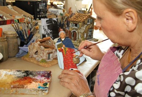 Mireille Fouque beim Bemalen einer Figur mit Ölfarbe.