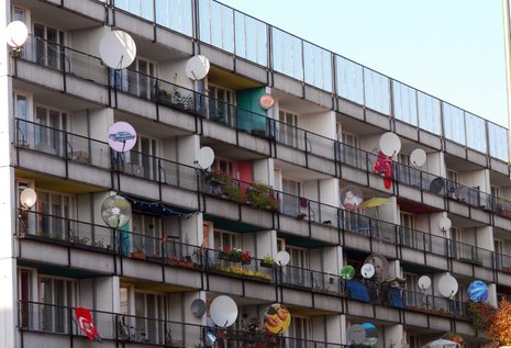 Satellitenschüsseln auf den Balkonen einer Wohnanlage in Berlin.