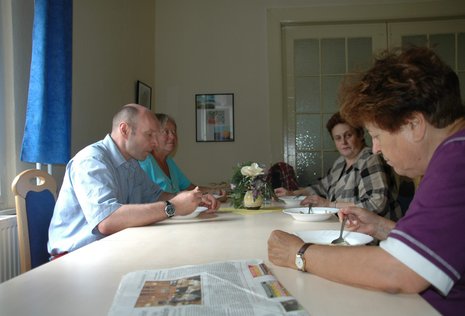 Udo Wolf (l.) beim gemeinsamen Essen mit Besetzerinnen.